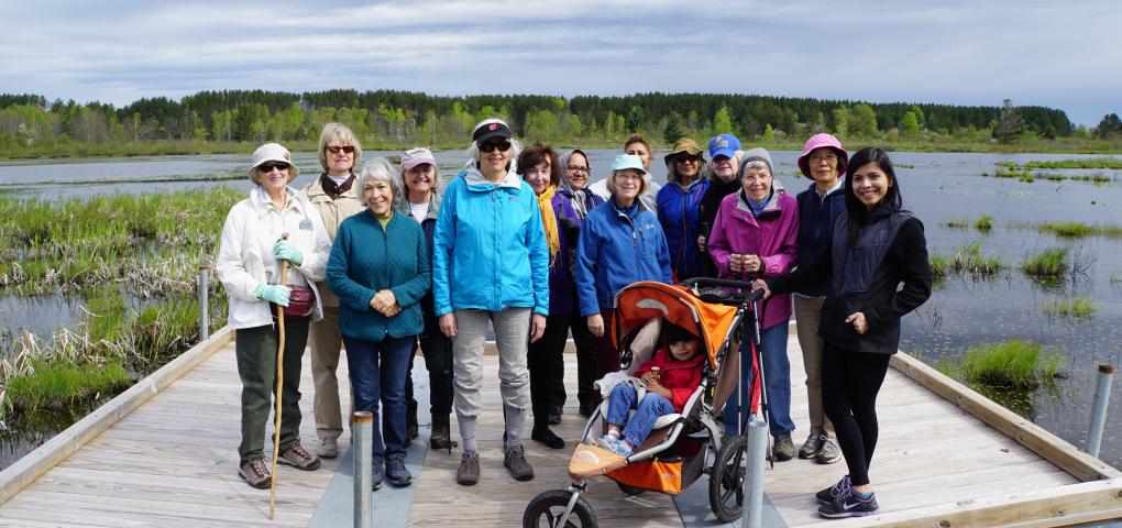 group of international visitors on floating platform with water in background