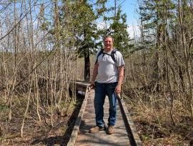 Stewardship Team Member Elam Maurer standing on a boardwalk.